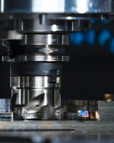 High-precision milling machine cutting a metal piece, showcasing industrial machinery.